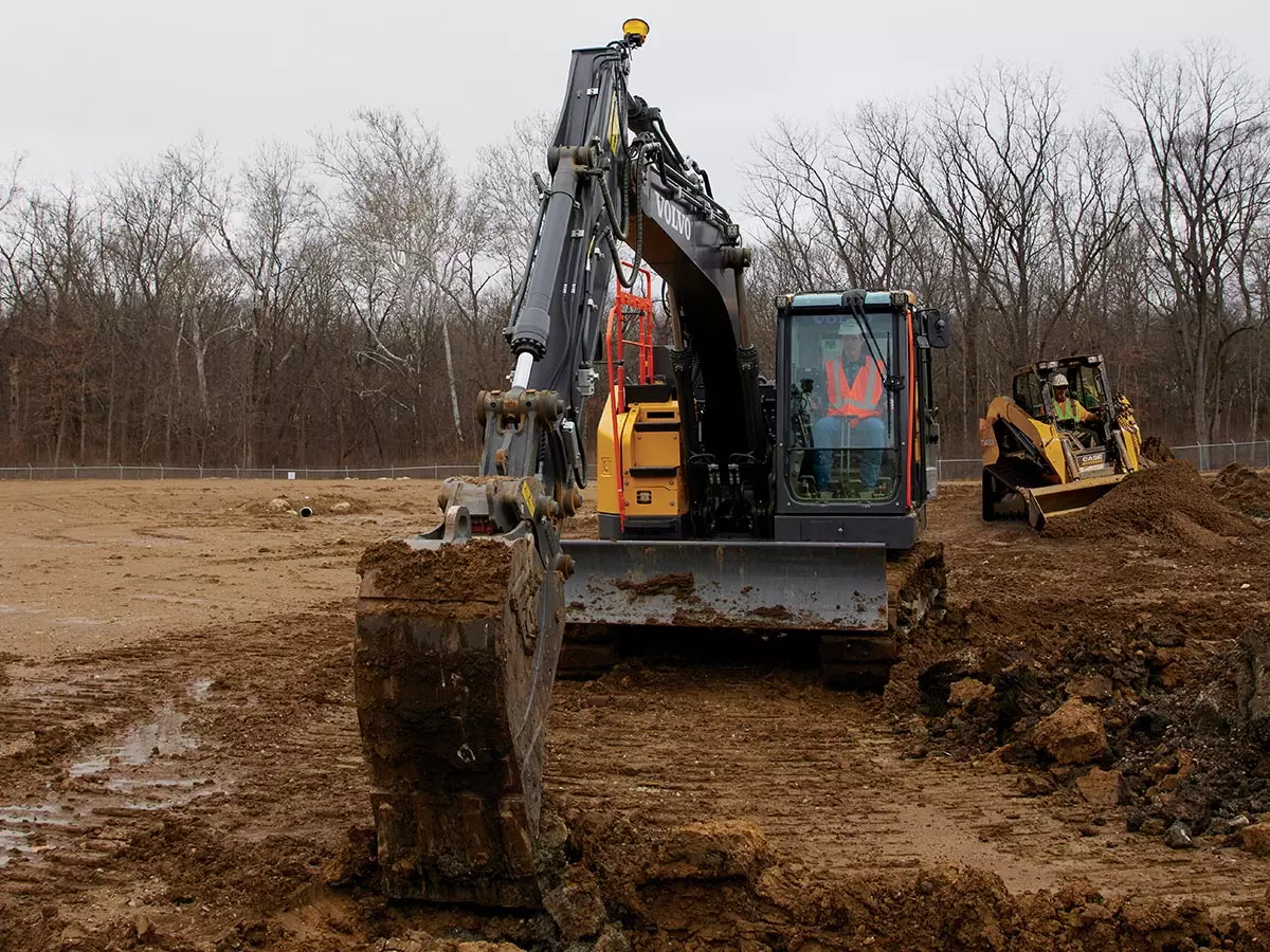 Excavator and compact track loader on work site