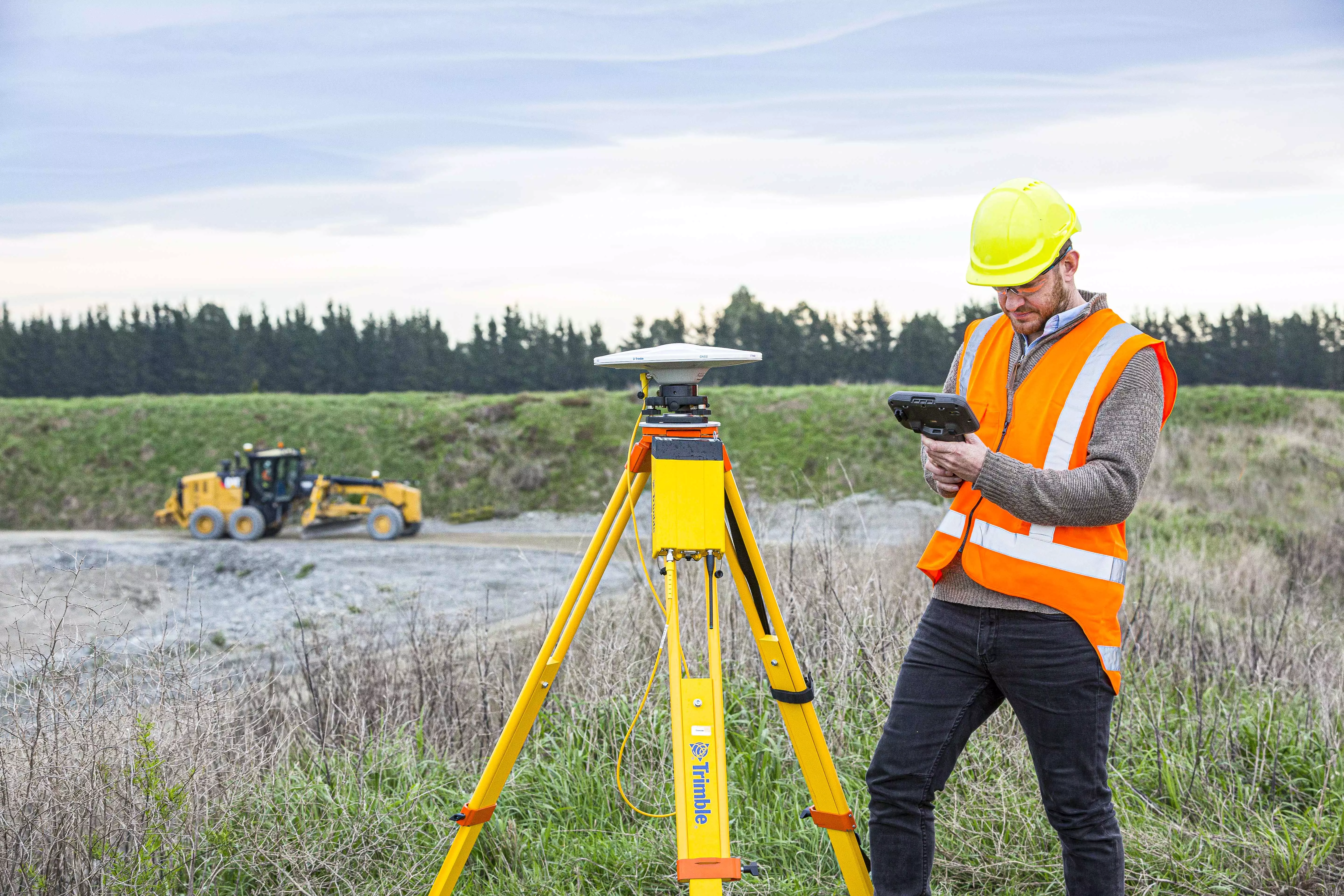 Surveyor in a field with a trimble reciver